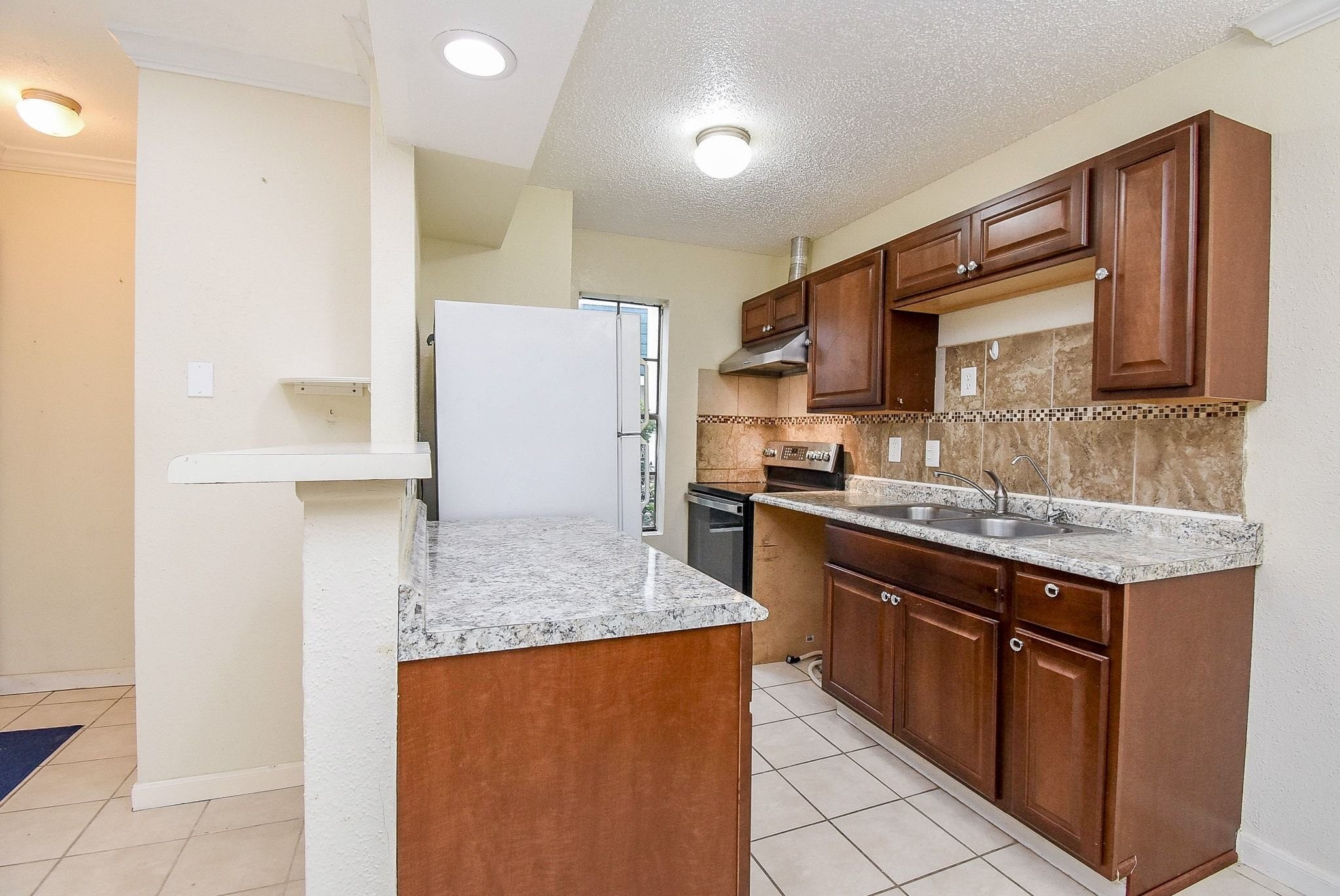 12660 Ashford Point Drive, Unit 507 Houston, TX 77082 - Photo 11 of 28 a kitchen with stainless steel appliances granite countertop a stove a sink and a refrigerator