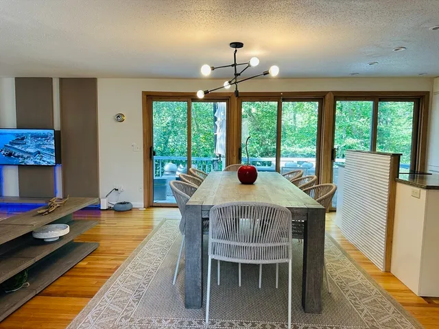 a view of a dining room with furniture a chandelier and wooden floor