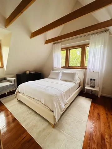 a large bed sitting in a bedroom next to a window