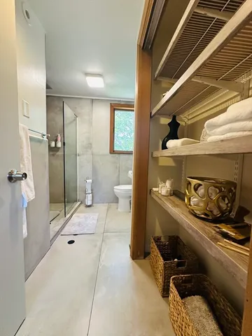 a bathroom with a granite countertop sink a toilet and shower