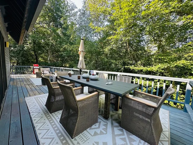 a view of a balcony with wooden floor and outdoor seating