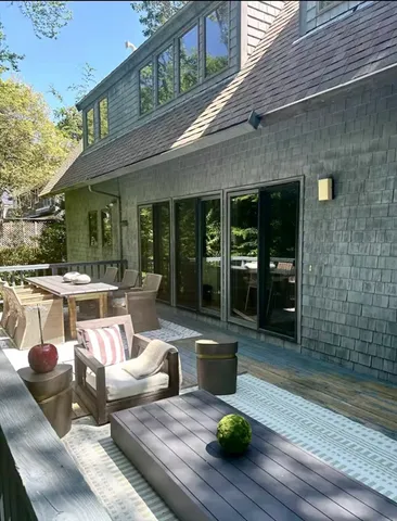 a living room with patio furniture and a wooden floor