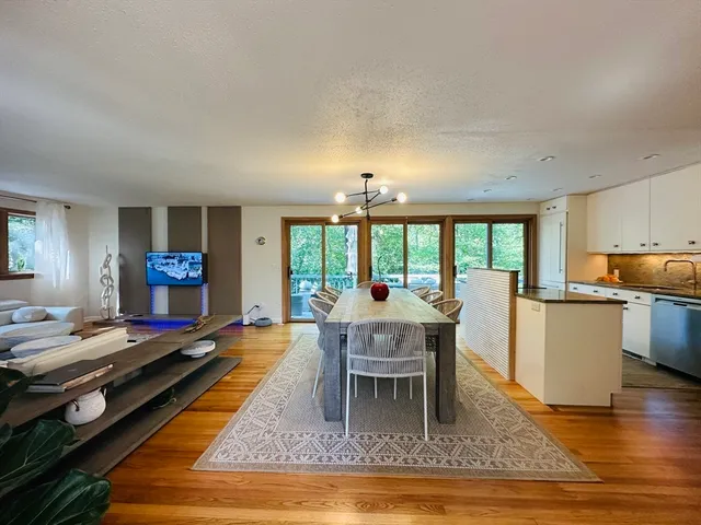 a living room with furniture a rug and a dining table