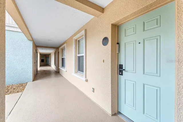 a living room with furniture two large windows and a flat screen tv