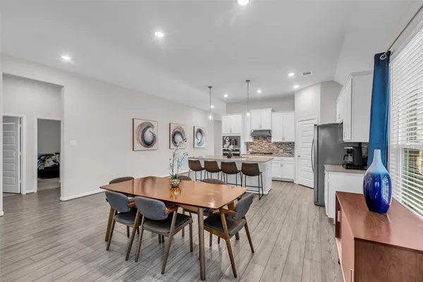 a kitchen with stainless steel appliances kitchen island granite countertop a stove top oven a sink a dining table and chairs