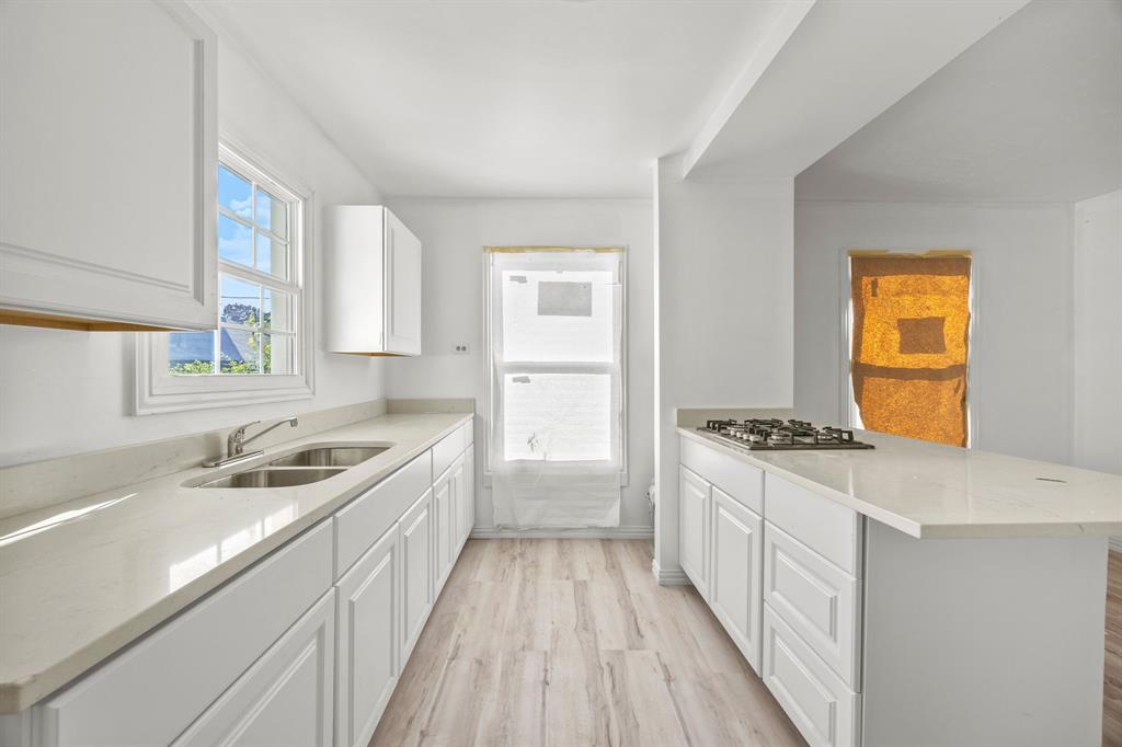 1802 Fordham Road Dallas, TX 75216 - Photo 11 of 25 a kitchen with granite countertop a sink and wooden cabinets