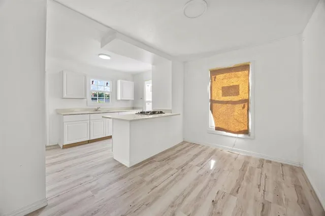 a view of a kitchen with wooden floor and a sink