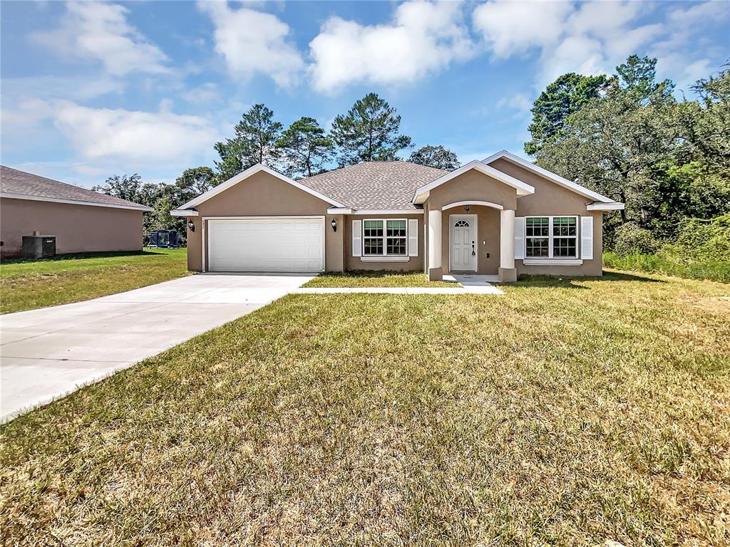 171 Oak Circle Ocala, FL 34472 - Photo 1 of 1 a front view of a house with a garden and trees