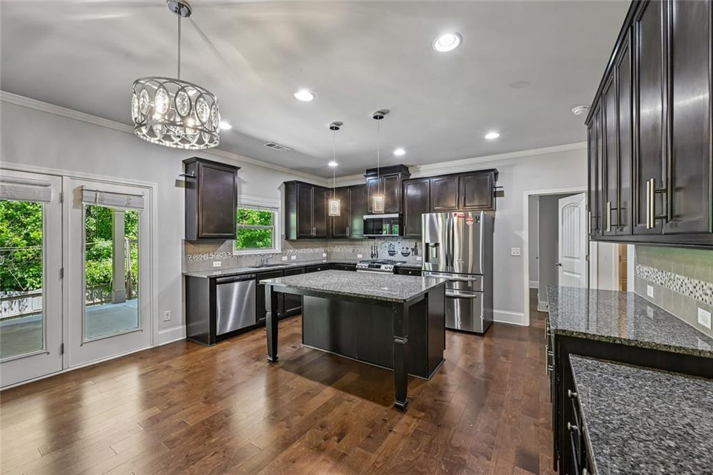 5378 Silverwoods Walk Powder Springs, GA 30127 - Photo 13 of 62 a kitchen with stainless steel appliances granite countertop a refrigerator a sink dishwasher a oven and a dining table with wooden floor