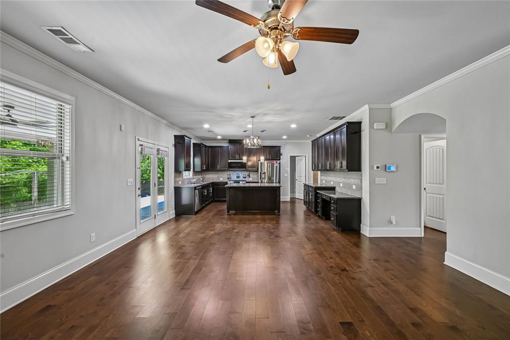 5378 Silverwoods Walk Powder Springs, GA 30127 - Photo 14 of 62 a view of a kitchen with kitchen island wooden floors appliances and a ceiling fan