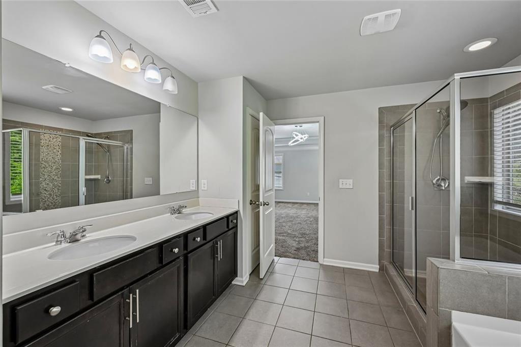5378 Silverwoods Walk Powder Springs, GA 30127 - Photo 28 of 62 a spacious bathroom with a double vanity sink mirror and shower