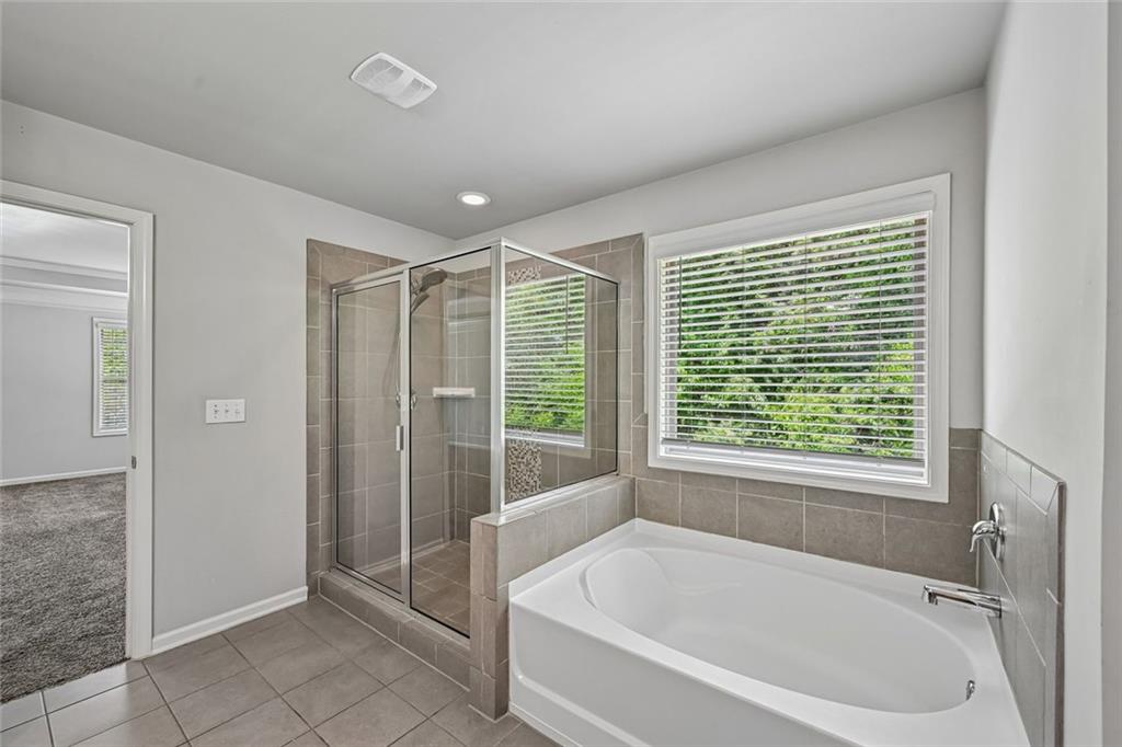 5378 Silverwoods Walk Powder Springs, GA 30127 - Photo 29 of 62 a white bath tub sitting in a bathroom next to a window