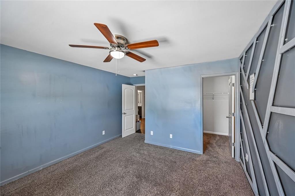 5378 Silverwoods Walk Powder Springs, GA 30127 - Photo 39 of 62 an empty room with staircase and a ceiling fan