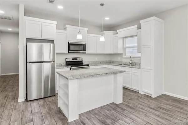 a kitchen with stainless steel appliances a refrigerator stove microwave and sink