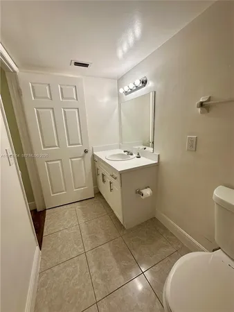 a bathroom with a sink a toilet and a mirror