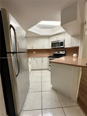 a kitchen with stainless steel appliances a refrigerator sink and microwave