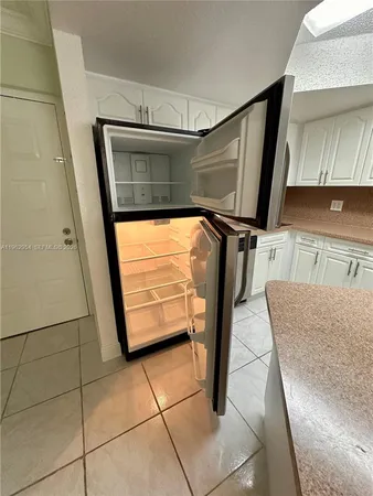 a kitchen with a refrigerator a sink and a stove top oven