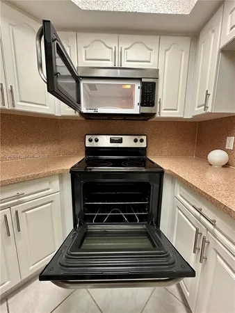 a stove top oven sitting inside of a kitchen