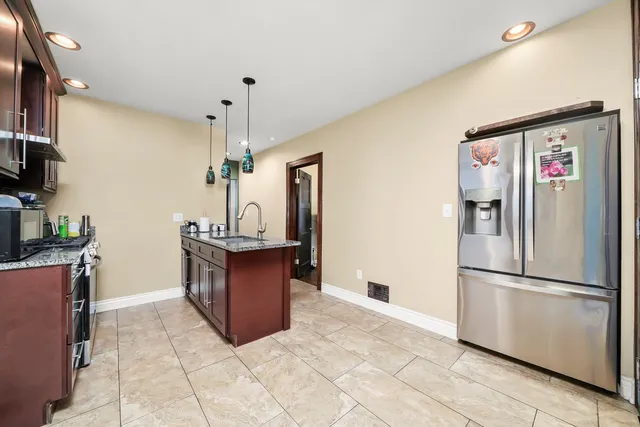 a kitchen with stainless steel appliances granite countertop a refrigerator and a stove top oven