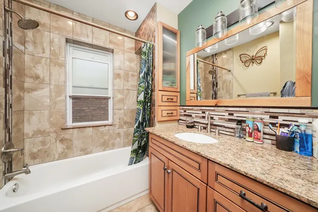 a bathroom with a granite countertop sink mirror bathtub and shower
