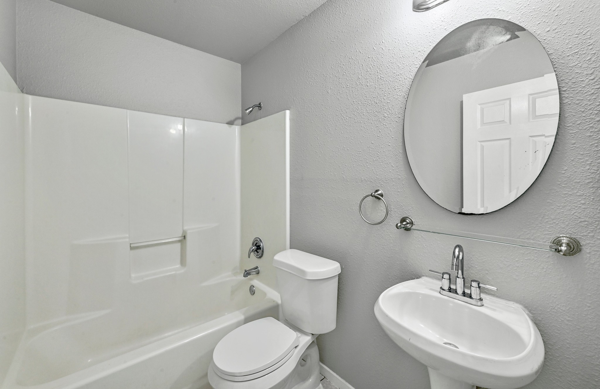 2212 Katy Lane Georgetown, TX 78626 - Photo 23 of 27 The bathroom features a white porcelain pedestal sink with a chrome faucet, a white toilet, and a white shower/tub combination with chrome fixtures