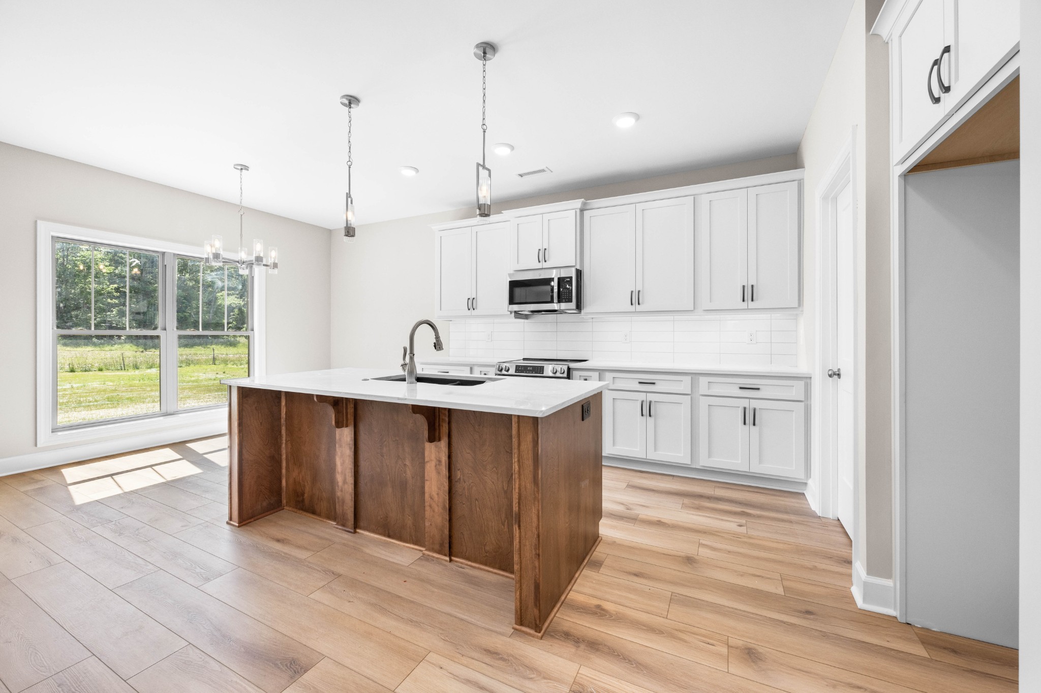 1456 Sango Commons Way Clarksville, TN 37043 - Photo 16 of 49 a kitchen with stainless steel appliances granite countertop a stove a sink dishwasher and a refrigerator with wooden floor