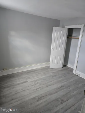 an empty room with wooden floor and entrance