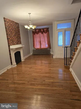 a view of a livingroom with wooden floor and a fireplace