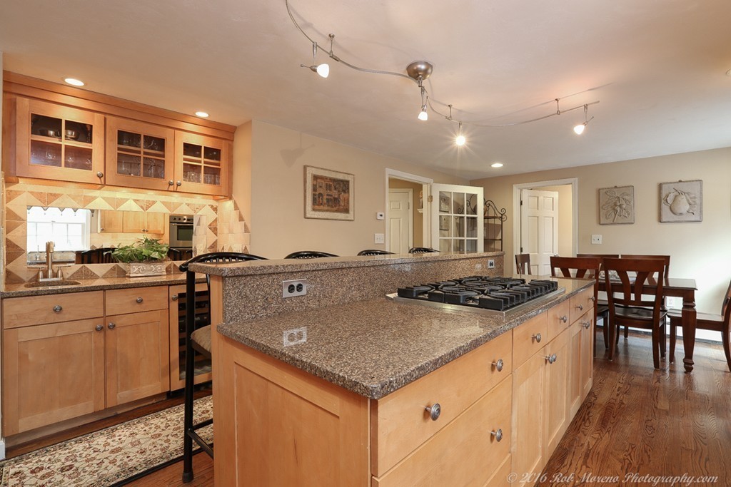 32 Olde Farms Road Boxford, MA 01921 - Photo 3 of 28 a kitchen with granite countertop a stove a sink a dining table and chairs