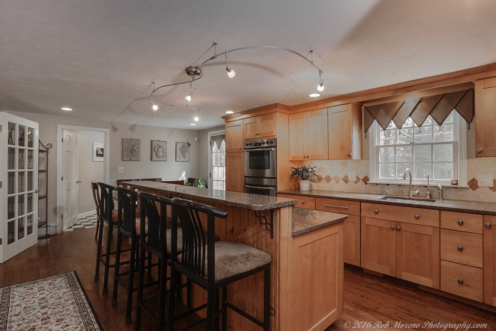 32 Olde Farms Road Boxford, MA 01921 - Photo 4 of 28 a kitchen with stainless steel appliances granite countertop a table chairs sink and cabinets