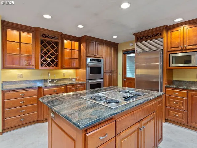 a kitchen with stainless steel appliances granite countertop a stove a sink and a refrigerator