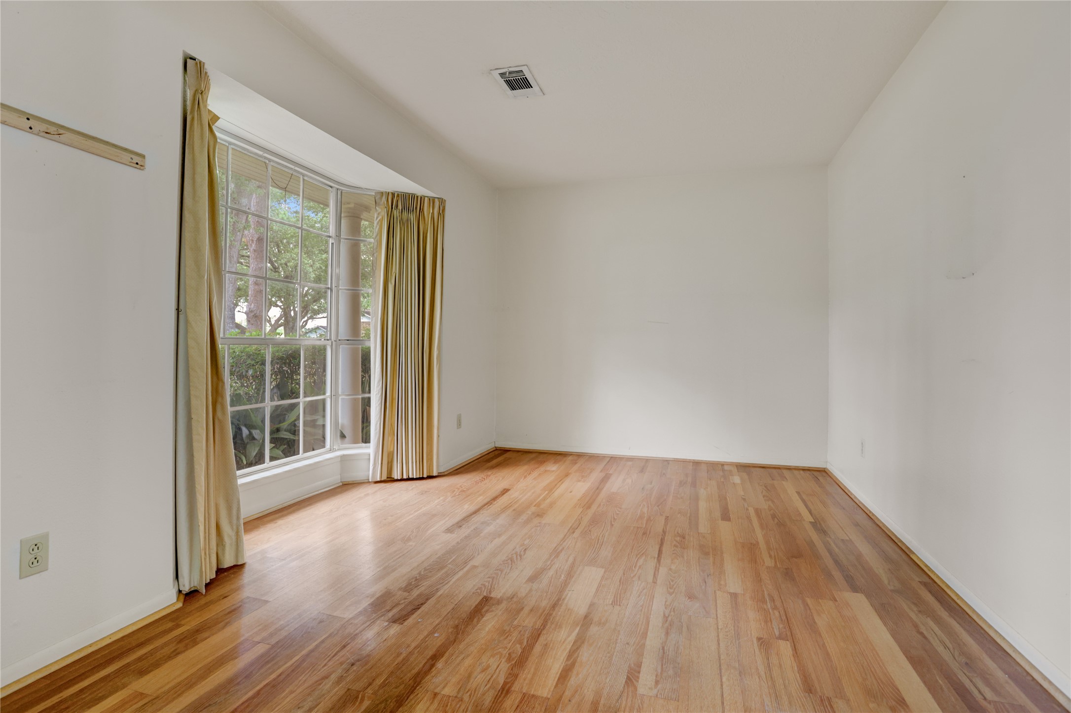105 Ridgemont Drive Alvin, TX 77511 - Photo 5 of 30 a view of an empty room with wooden floor and a window