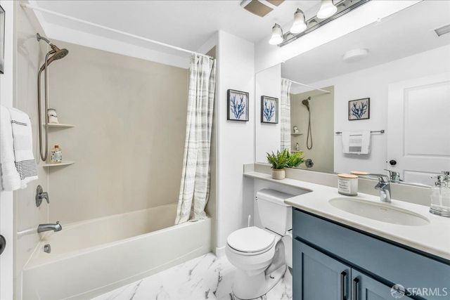 a bathroom with a sink a toilet a mirror a bathtub and shower