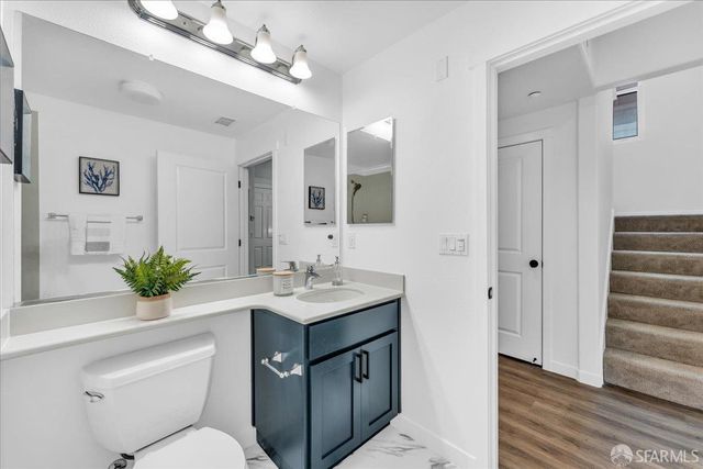 a bathroom with a sink vanity granite and toilet