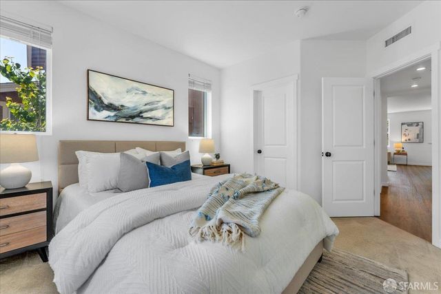 a bedroom with a bed and a painting on the wall