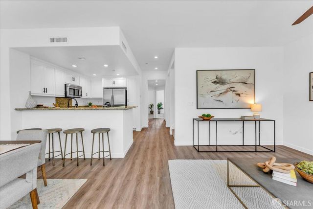 a living room with stainless steel appliances furniture a kitchen view and kitchen island