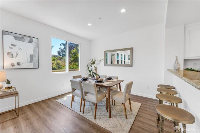 a view of a dining room with furniture a rug and wooden floor