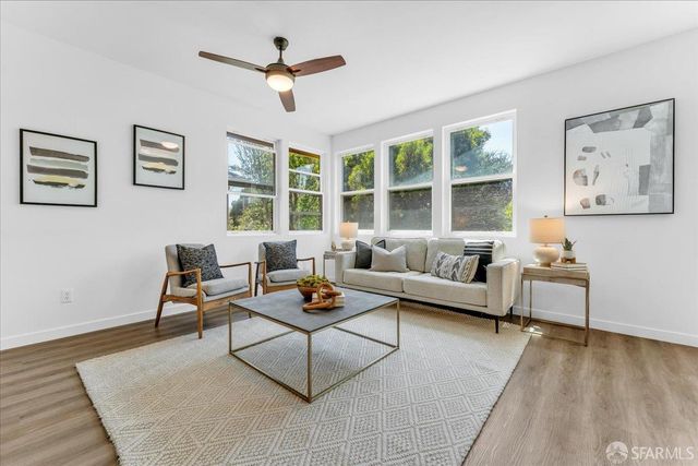 a living room with furniture a large window and a table