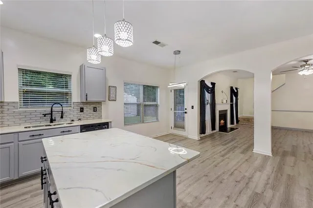 a large white kitchen with lots of counter space a refrigerator and cabinets