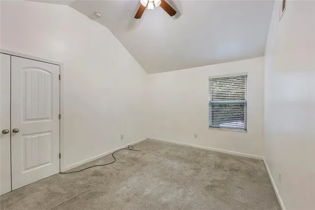 an empty room with windows and fan view