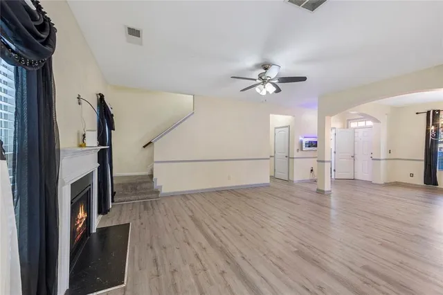 a view of a livingroom with wooden floor and a ceiling fan