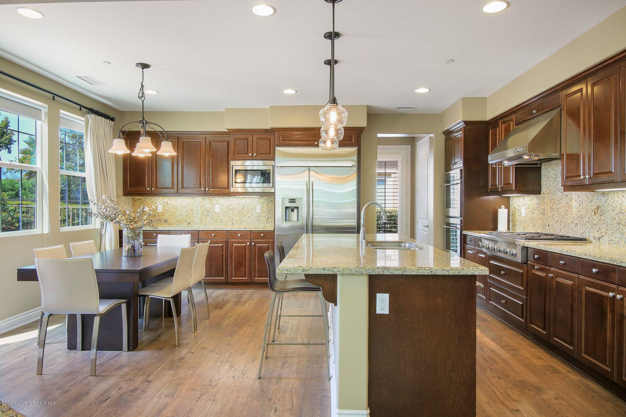 3406 Avondale Road Pasadena, CA 91107 - Photo 9 of 22 a large kitchen with granite countertop a stove a sink a refrigerator and a dining table with wooden floor