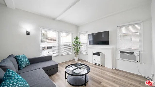 a living room with furniture a flat screen tv and a fireplace