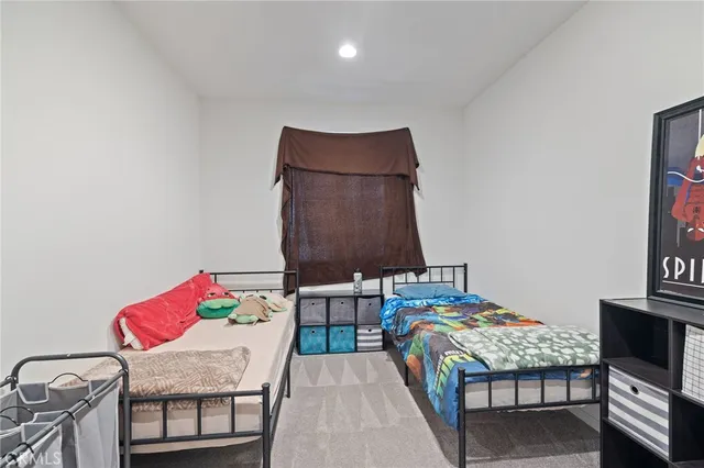 a bedroom with a bed and teddy bear on bed