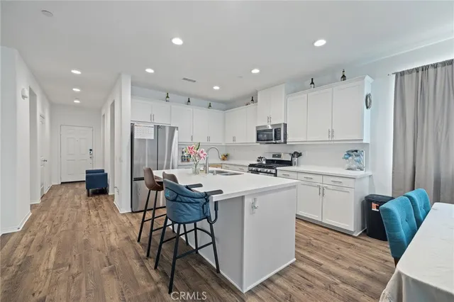 a kitchen with refrigerator a sink and chairs