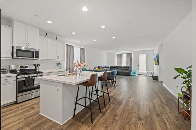 a kitchen with a sink a counter top space stainless steel appliances and wooden floor
