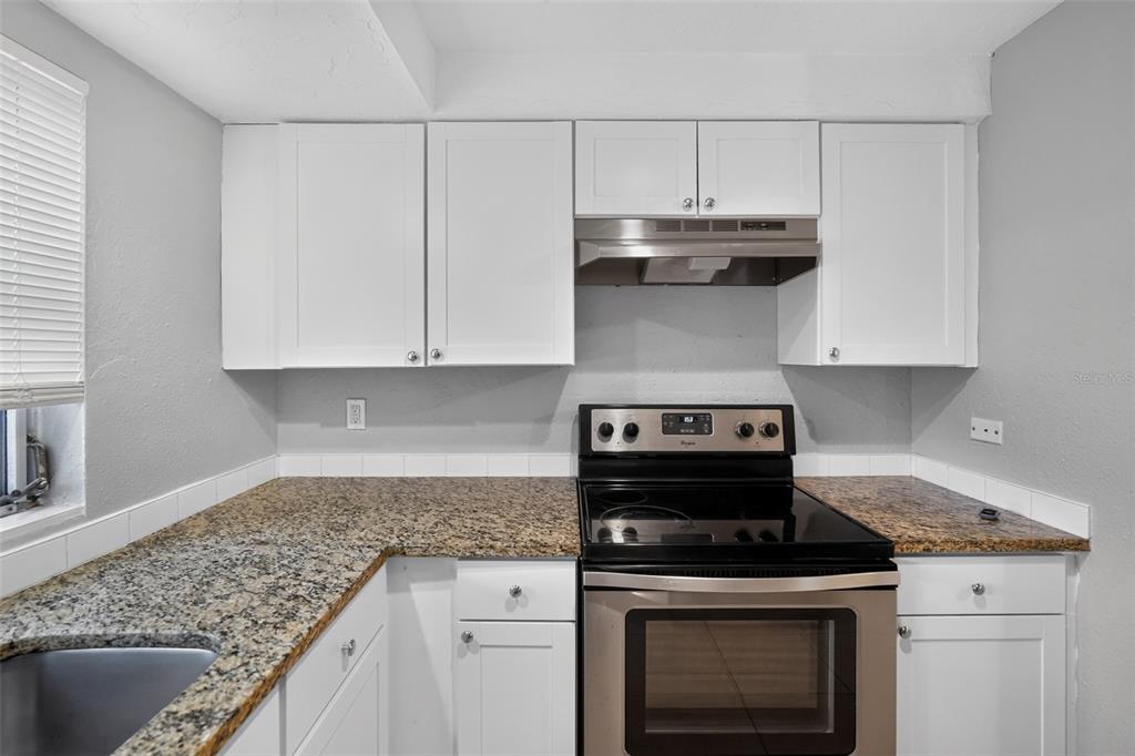 3834 Warren Ridge Street Sarasota, FL 34233 - Photo 4 of 31 a stove top oven sitting inside of a kitchen
