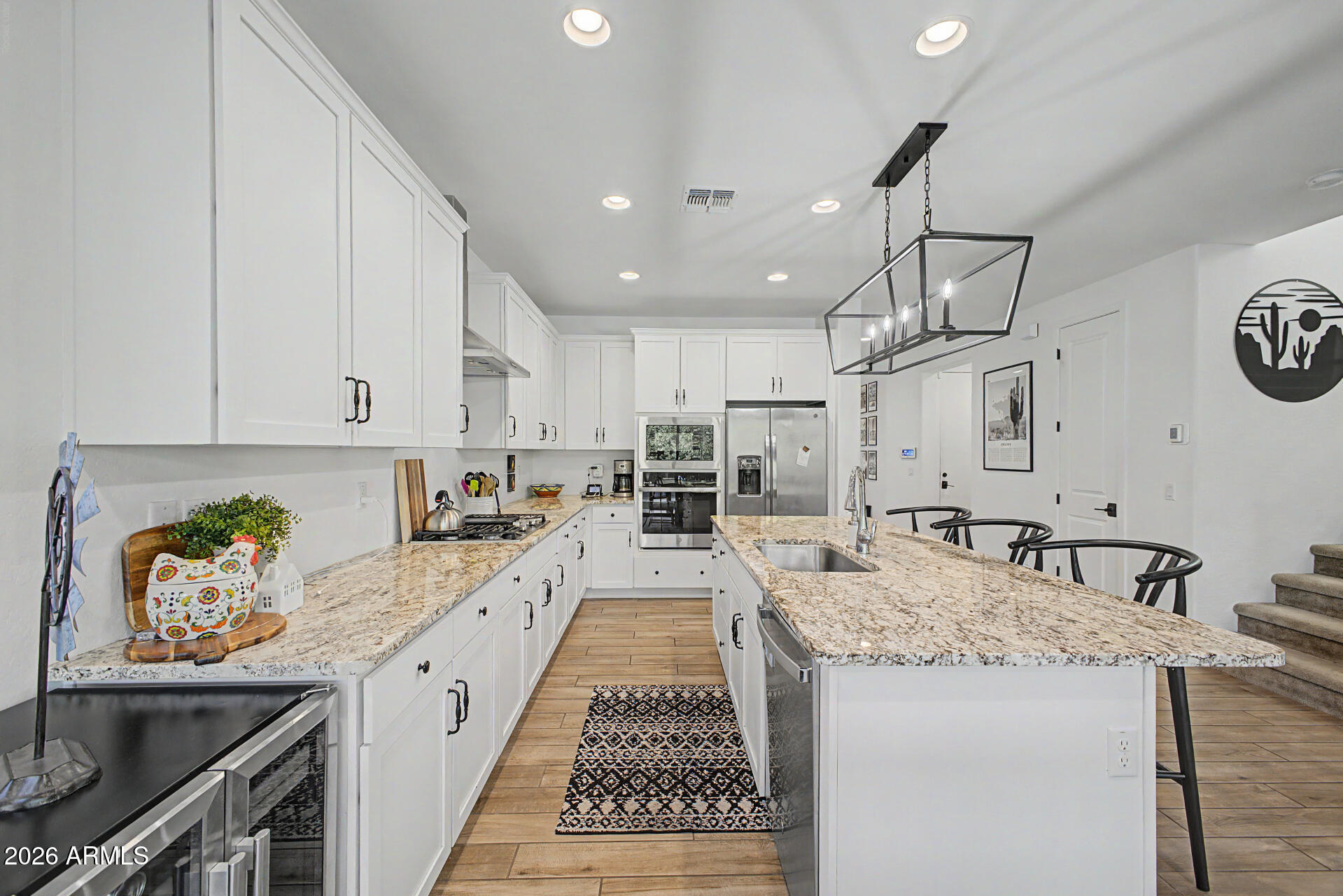 819 West Deer Creek Road Phoenix, AZ 85048 - Photo 27 of 76 a large kitchen with kitchen island a stove a sink a center island and furniture
