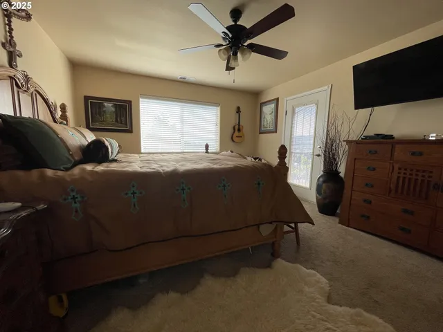a bedroom with a bed closet and a flat tv screen