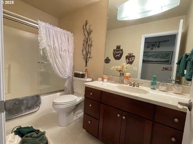 a bathroom with a double vanity sink toilet mirror and shower